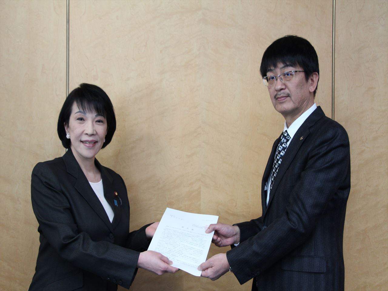 高市総務大臣(左)に要求書を手交する川本副議長(右)