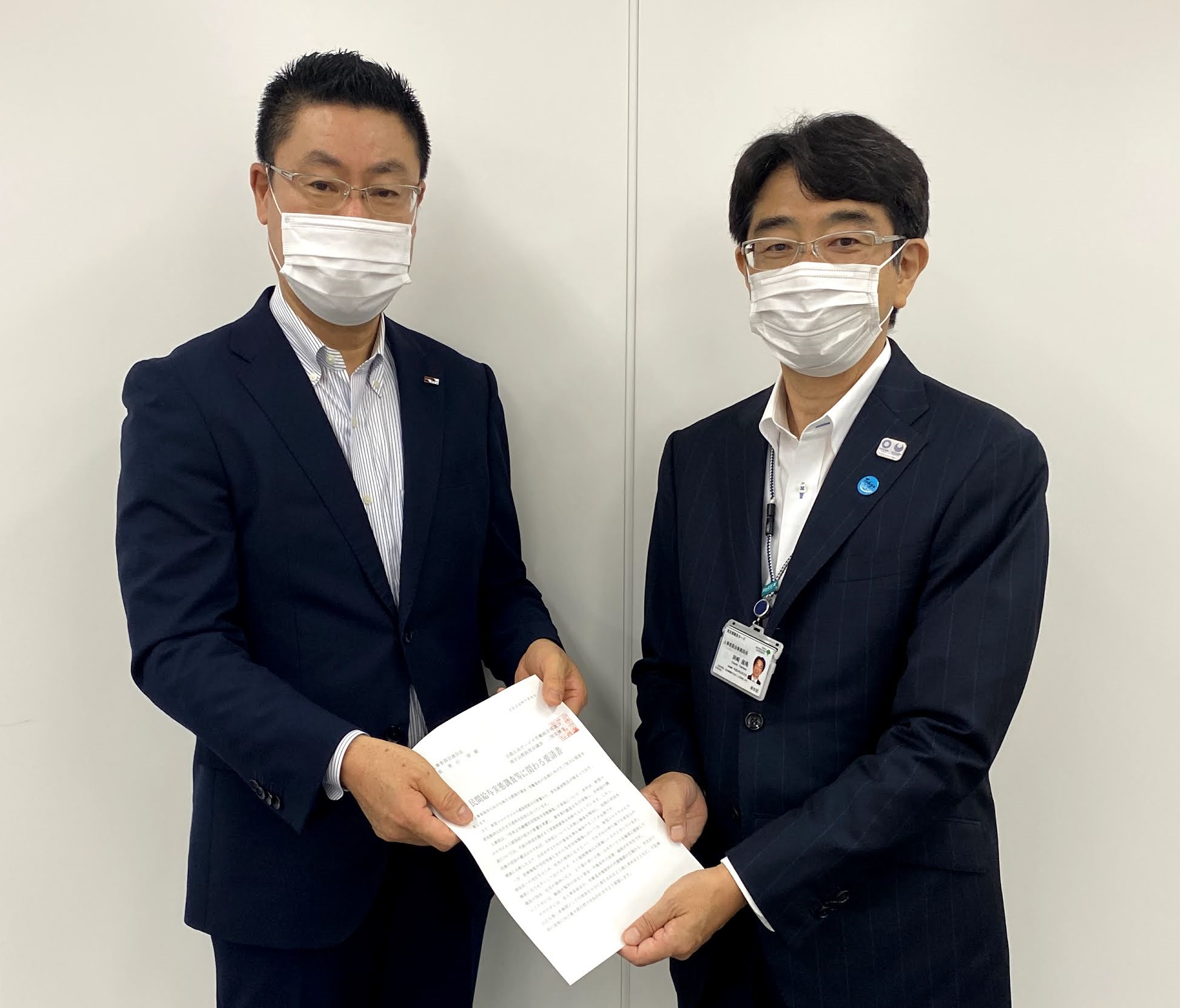 岡崎事務局長(右)に要請書を手交する二階堂議長(左)